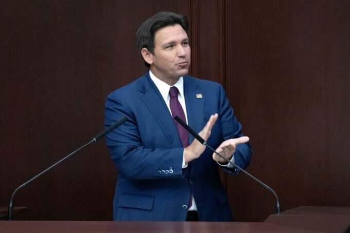 Reducción de impuestos inmobiliarios en Florida irá a voto El gobernador de Florida Ron DeSantis con traje azul en un podio hablando sobre la reducción de impuestos inmobiliarios.