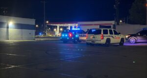 Tiroteo en Midfield activa investigación policial urgente Patrullas de policía con luces intermitentes azules encendidas estacionadas de noche en el estacionamiento de una gasolinera en Midfield durante una investigación.