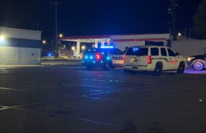Tiroteo en Midfield activa investigación policial urgente Patrullas de policía con luces intermitentes azules encendidas estacionadas de noche en el estacionamiento de una gasolinera en Midfield durante una investigación.