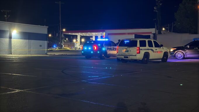 Tiroteo en Midfield activa investigación policial urgente Patrullas de policía con luces intermitentes azules encendidas estacionadas de noche en el estacionamiento de una gasolinera en Midfield durante una investigación.