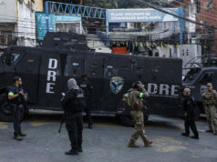 Tiroteo en Río de Janeiro deja atrapados a 50 turistas en favela Santa Marta Agentes armados junto a un camión blindado DRE de la Policía Civil en la entrada de la comunidad Santa Marta en Río de Janeiro.