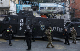 Tiroteo en Río de Janeiro deja atrapados a 50 turistas en favela Santa Marta Agentes armados junto a un camión blindado DRE de la Policía Civil en la entrada de la comunidad Santa Marta en Río de Janeiro.