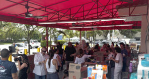 Envían ayuda médica de emergencia a Venezuela desde Miami Voluntarios clasifican insumos médicos y cajas de ayuda humanitaria bajo un toldo rojo para enviar a Venezuela.