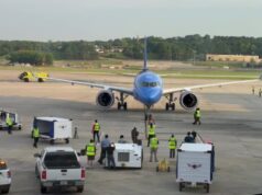 Breeze Airways estrena nuevos vuelos directos desde Birmingham Avión azul de Breeze Airways en la pista del aeropuerto de Birmingham atendido por personal terrestre.