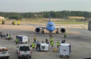 Breeze Airways estrena nuevos vuelos directos desde Birmingham Avión azul de Breeze Airways en la pista del aeropuerto de Birmingham atendido por personal terrestre.