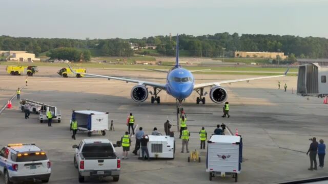 birmingham-breeze-airways-primer-vuelo-sin-escalas Avión azul de Breeze Airways en la pista del aeropuerto de Birmingham atendido por personal terrestre.