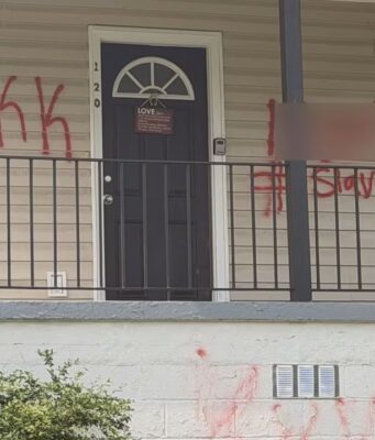 Casa en Birmingham sufre vandalismo con insultos raciales Fachada de una casa vandalizada con las siglas KKK y la palabra Slavery pintadas en aerosol rojo en Birmingham.