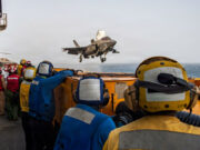 EE. UU. y Arabia Saudí bombardean posiciones en Irak Caza F-35 despega desde un portaviones estadounidense bajo la supervisión de la tripulación en cubierta.