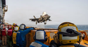 EE. UU. y Arabia Saudí bombardean posiciones en Irak Caza F-35 despega desde un portaviones estadounidense bajo la supervisión de la tripulación en cubierta.