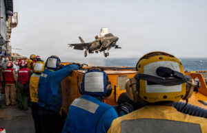 EE. UU. y Arabia Saudí bombardean posiciones en Irak Caza F-35 despega desde un portaviones estadounidense bajo la supervisión de la tripulación en cubierta.