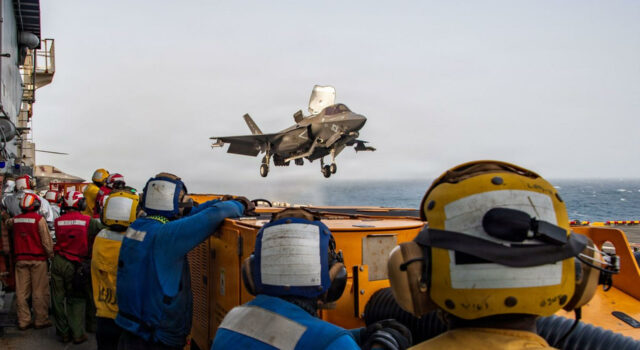 EE. UU. y Arabia Saudí bombardean posiciones en Irak Caza F-35 despega desde un portaviones estadounidense bajo la supervisión de la tripulación en cubierta.