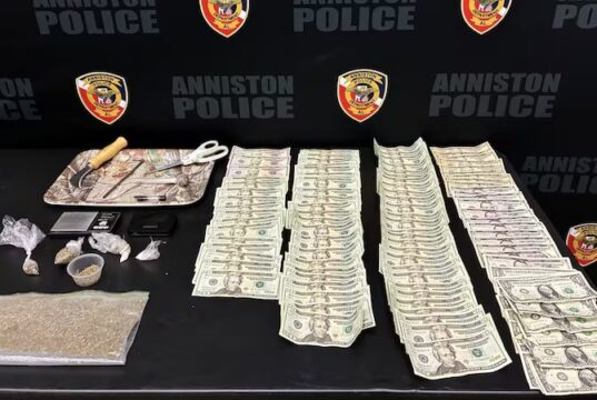 Operativo en Anniston deja 6 arrestados y drogas incautadas Incautación de drogas, billetes de dólares y parafernalia expuestos sobre una mesa de la policía de Anniston.