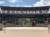 Alabama elige al Zoológico de Birmingham atracción del año Entrada principal del Zoológico de Birmingham en Alabama con el letrero gigante en letras blancas bajo un cielo despejado.