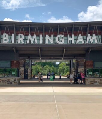 Alabama elige al Zoológico de Birmingham atracción del año Entrada principal del Zoológico de Birmingham en Alabama con el letrero gigante en letras blancas bajo un cielo despejado.