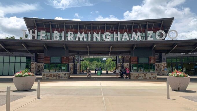 Alabama elige al Zoológico de Birmingham atracción del año Entrada principal del Zoológico de Birmingham en Alabama con el letrero gigante en letras blancas bajo un cielo despejado.