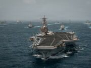 Alerta mundial de viaje ante una escalada en Oriente Medio Portaaviones de Estados Unidos navegando en mar abierto junto a flota de buques de guerra.