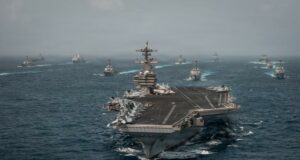 Alerta mundial de viaje ante una escalada en Oriente Medio Portaaviones de Estados Unidos navegando en mar abierto junto a flota de buques de guerra.