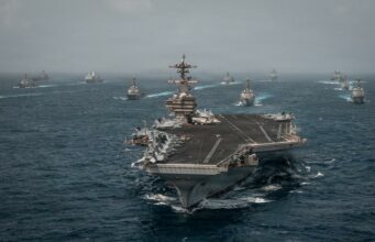 Alerta mundial de viaje ante una escalada en Oriente Medio Portaaviones de Estados Unidos navegando en mar abierto junto a flota de buques de guerra.
