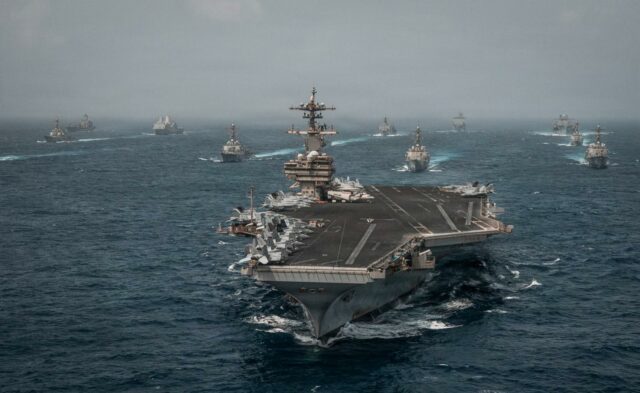 Alerta mundial de viaje ante una escalada en Oriente Medio Portaaviones de Estados Unidos navegando en mar abierto junto a flota de buques de guerra.