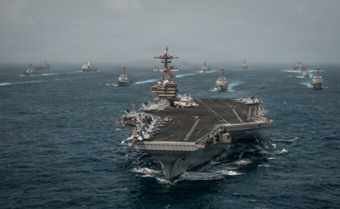 Alerta mundial de viaje ante una escalada en Oriente Medio Portaaviones de Estados Unidos navegando en mar abierto junto a flota de buques de guerra.