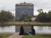 Examen UNAM 2026 bajo revisión por sospecha de uso de IA Estudiantes sentados frente al espejo de agua con el edificio de Rectoría de la UNAM al fondo en México.