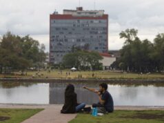 Examen UNAM 2026 bajo revisión por sospecha de uso de IA Estudiantes sentados frente al espejo de agua con el edificio de Rectoría de la UNAM al fondo en México.