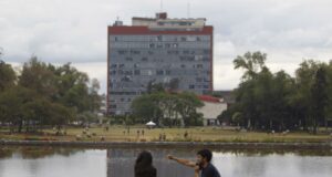 Examen UNAM 2026 bajo revisión por sospecha de uso de IA Estudiantes sentados frente al espejo de agua con el edificio de Rectoría de la UNAM al fondo en México.
