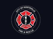 Huntsville aprueba terreno para nueva estación de bomberos Escudo oficial de Huntsville Fire and Rescue con la figura de un cohete espacial sobre fondo negro.