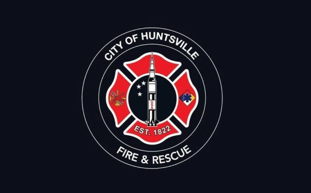 Escudo oficial de Huntsville Fire and Rescue con la figura de un cohete espacial sobre fondo negro.