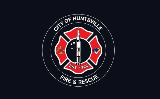 Huntsville aprueba terreno para nueva estación de bomberos Escudo oficial de Huntsville Fire and Rescue con la figura de un cohete espacial sobre fondo negro.
