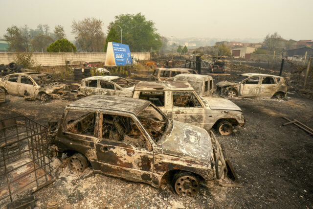 Múltiples automóviles destruidos y calcinados por el paso de un devastador incendio forestal.