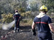 Incendios masivos en Francia arrasan miles de hectáreas Dos bomberos rociando agua sobre matorrales quemados durante los incendios en Francia.