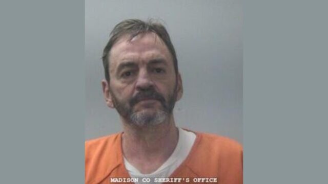 Fotografía de arresto de Jimmy Lewis Price Jr con uniforme naranja en la oficina del sheriff de Madison.