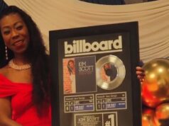 Kim Scott alcanza nuevo éxito número uno en Billboard La flautista Kim Scott sostiene un cuadro conmemorativo del número uno de Billboard por su canción Hide and Seek.