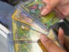 Alabama sufre ola de robos de valiosas cartas de Pokémon Manos sosteniendo cartas coleccionables de Pokémon en fundas protectoras como Raichu y Gengar en una tienda de Alabama.