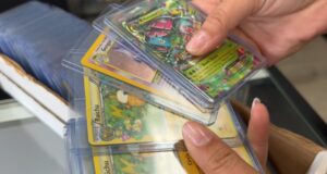 Alabama sufre ola de robos de valiosas cartas de Pokémon Manos sosteniendo cartas coleccionables de Pokémon en fundas protectoras como Raichu y Gengar en una tienda de Alabama.