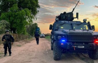 México confirma la muerte de 10 criminales en Sinaloa Vehículo blindado de la Policía Estatal y agentes armados resguardan un camino rural durante un operativo en México.