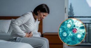 Alerta de salud por brote de ciclosporiasis y diarrea Mujer sentada en la cama expresando dolor abdominal intenso junto a micrografía del parásito Cyclospora cayetanensis.