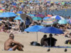 Ola de calor en Europa deja miles de muertos por temperaturas extremas Playa repleta de personas bajo sombrillas de colores para protegerse de la intensa ola de calor en Europa.