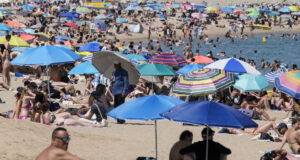 Ola de calor en Europa deja miles de muertos por temperaturas extremas Playa repleta de personas bajo sombrillas de colores para protegerse de la intensa ola de calor en Europa.