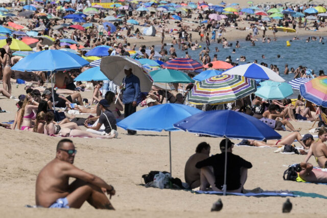 Las altas temperaturas siguen castigando a Europa Playa repleta de personas bajo sombrillas de colores para protegerse de la intensa ola de calor en Europa.