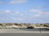 Piura registra temperaturas récord por El Niño Costero Persona camina por un terreno desértico de Piura con viviendas rústicas bajo un cielo despejado por El Niño Costero.