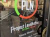 Project Lean Nation llega a Homewood con nutrición Fachada de Project Lean Nation en Homewood con su logotipo PLN y horarios de atención en la puerta de vidrio.