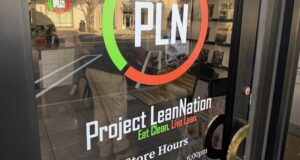 Project Lean Nation llega a Homewood con nutrición Fachada de Project Lean Nation en Homewood con su logotipo PLN y horarios de atención en la puerta de vidrio.