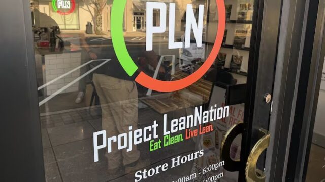 Fachada de Project Lean Nation en Homewood con su logotipo PLN y horarios de atención en la puerta de vidrio.