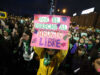 Protestas en Chile contra ley de latidos fetales y aborto Manifestante sostiene un cartel rosa sobre el aborto libre durante una marcha nocturna en Chile.
