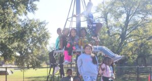 Birmingham aprueba presupuesto millonario enfocado en juventud El alcalde Randall L. Woodfin posa junto a un grupo de niños en una estructura de juego de un parque en Birmingham.