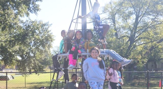 Birmingham aprueba presupuesto millonario enfocado en juventud El alcalde Randall L. Woodfin posa junto a un grupo de niños en una estructura de juego de un parque en Birmingham.