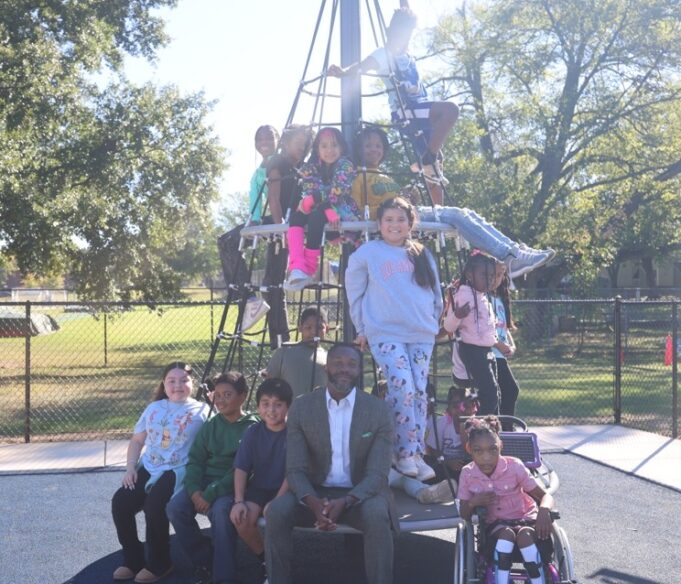 Birmingham aprueba presupuesto millonario enfocado en juventud El alcalde Randall L. Woodfin posa junto a un grupo de niños en una estructura de juego de un parque en Birmingham.