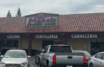 Inmigración en San Diego frena un operativo del ICE Fachada del mercado mexicano en San Diego con el letrero 'Manolo Farmers Market', mostrando carnicería y tortillería bajo el sol.